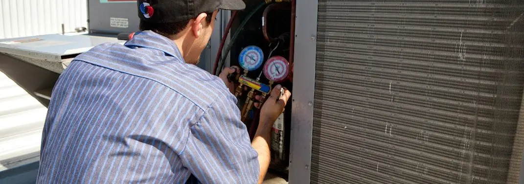 HVAC technician servicing a condenser unit in Gatesville