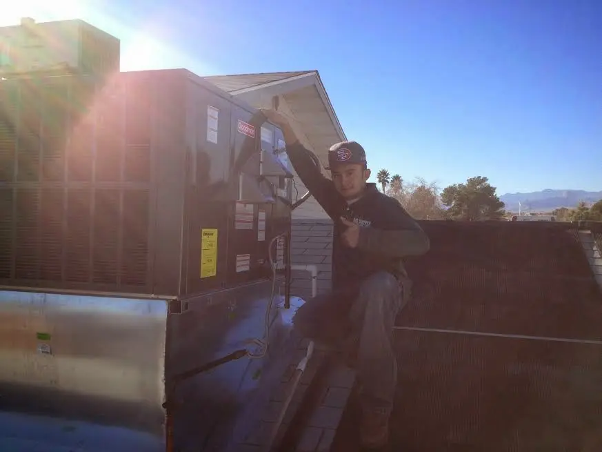 HVAC technician performing Air Duct Repair on a rooftop unit in Gatesville